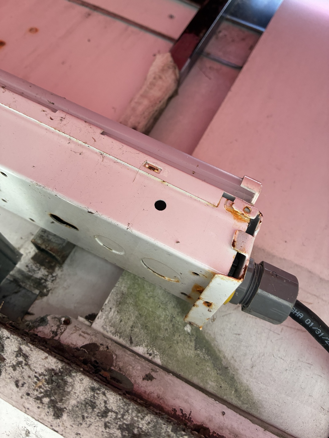 Corrosion on old commercial exterior light fixture before replacement