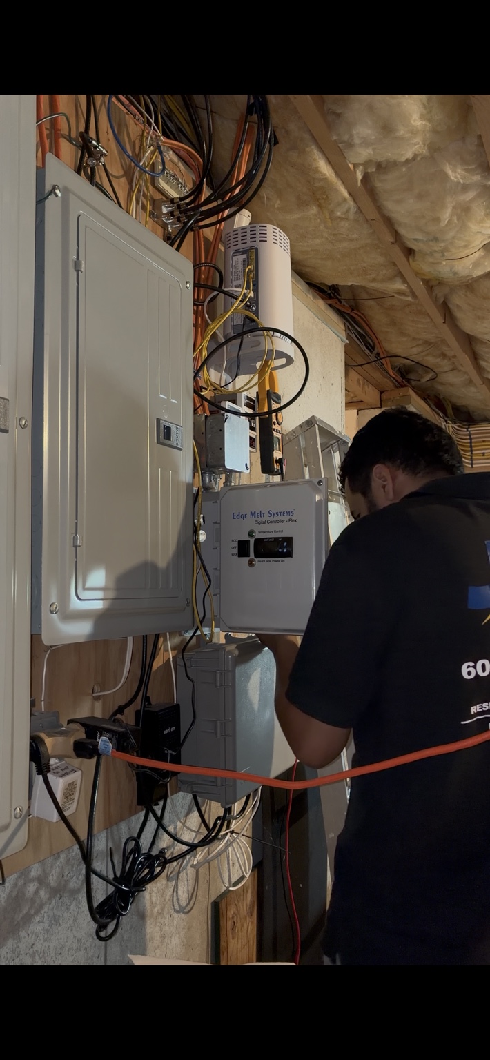 Electrician troubleshooting an ice melt heat cable system