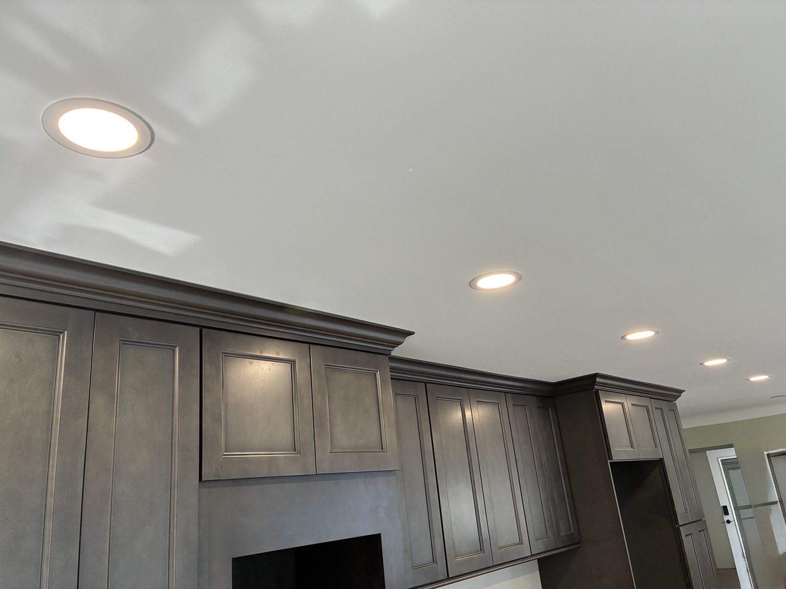 Finished kitchen with recessed lights at full brightness